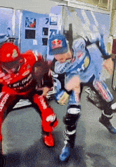 a man wearing a red bull hat is fighting another man wearing a blue hat