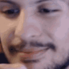 a man with a beard is smiling and looking at the camera