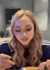 a woman with blonde hair is eating a meal with a fork