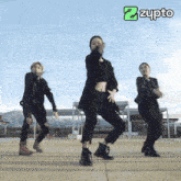 three women are dancing in front of an ad for zupto