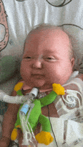 a baby is laying in a hospital bed with an oxygen mask on