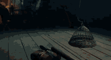 a wicker cage is sitting on a wooden floor in a dark room with a person standing in the background .