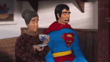 a man in a superman costume sits next to an older woman