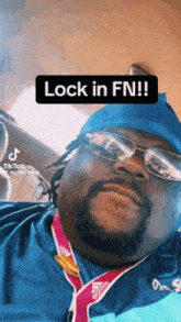 a man with glasses and a medal around his neck says lock in fn !!