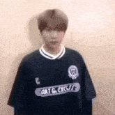 a young man is wearing a blue soccer jersey and standing in front of a wall .