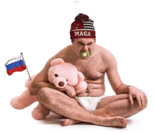 a man wearing a maga hat is holding a teddy bear