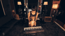 a man is playing a m-audio keyboard with a dog