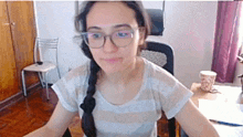a woman wearing glasses is sitting at a desk in a living room .