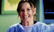 a close up of a woman wearing a scrub top and smiling .