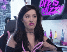 a woman sitting in front of a sign that says life is sizzly