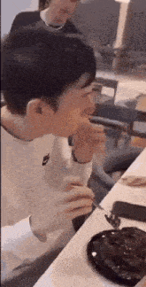 a man is eating a piece of chocolate cake with a fork .