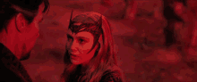 doctor strange and scarlet witch are looking at each other in a red light .