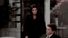 a man and a woman are standing next to each other in front of a door .