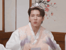 a man wearing a pink vest and a tiara