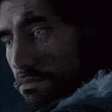 a close up of a man with a beard and a bloody eye .