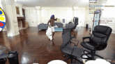 a man is dancing in a living room with a clock that says 61 : 5244