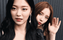 two women are posing for a picture and one of them is waving