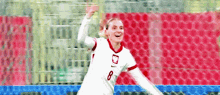 a female soccer player wearing a white jersey with the number 8 on it