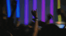 a blurred image of people raising their hands in the air