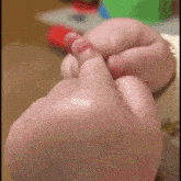 a close up of a baby 's hand holding another hand