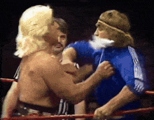 two men are wrestling in a ring with one wearing a headband