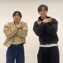 two men standing next to each other with their hands folded in front of their chests