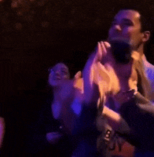 a group of people are dancing in a dark room