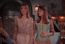 two women are standing next to each other and one is wearing a corset