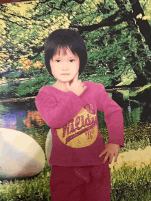 a little girl wearing a pink shirt that says mildly
