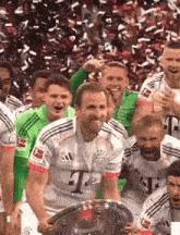 a man wearing a t-mobile jersey holds a trophy