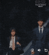 a man in a suit and tie is walking next to a woman in a suit