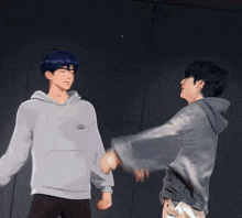 a couple of men are standing next to each other with their hands in the air