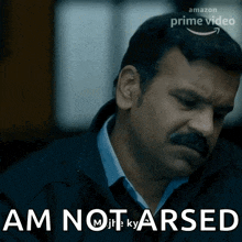 a man with a mustache says " am not arsed " in front of him