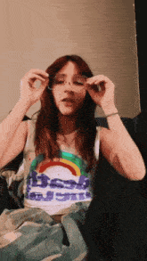 a girl wearing a tank top that says ' rainbow ' on it