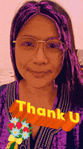 a woman wearing glasses and a purple wig has a thank you sticker on her shirt