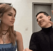 a man and a woman are standing next to each other and talking to each other .