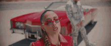 a woman wearing red sunglasses sticks her tongue out