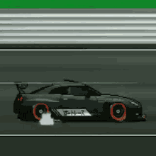a black car with red wheels is on a race track