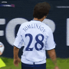 a soccer player wearing a white shirt with the number 28 on it