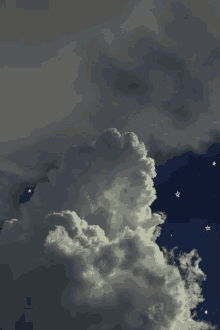 a cloudy night sky with a shooting star in the middle