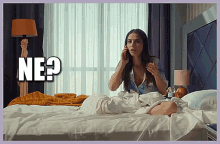 a woman is sitting on a bed talking on a cell phone with the word ne written above her