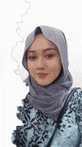 a woman wearing a gray hijab and a blue shirt