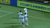 a group of soccer players are celebrating a goal on a field with an espn ad behind them