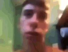 a blurry picture of a man 's face with a green wall in the background