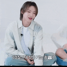 a man in a striped shirt sits on the floor next to a woman in a white shirt