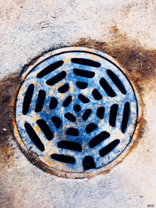 a manhole cover has a circular pattern on it and says aux on the bottom right