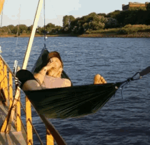 a man laying in a hammock on a boat