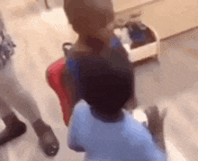a group of children are standing next to each other on a wooden floor in a room .