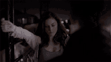 a woman is holding a man 's arm in a dark room .