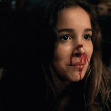 a girl with blood on her face and the words beatrice is a badass below her